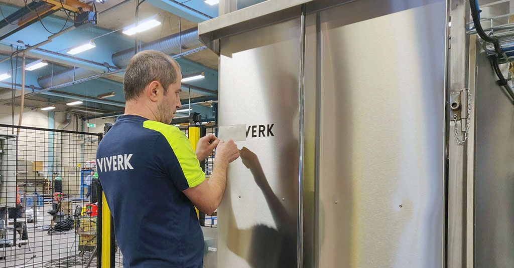 Bekir Özkan, är ansvarig maskinbyggare, har varit med från att sätta första svetsen till att lägga sista ”touchen”, här med att sätta Viverks nya logga på anläggningens front. 