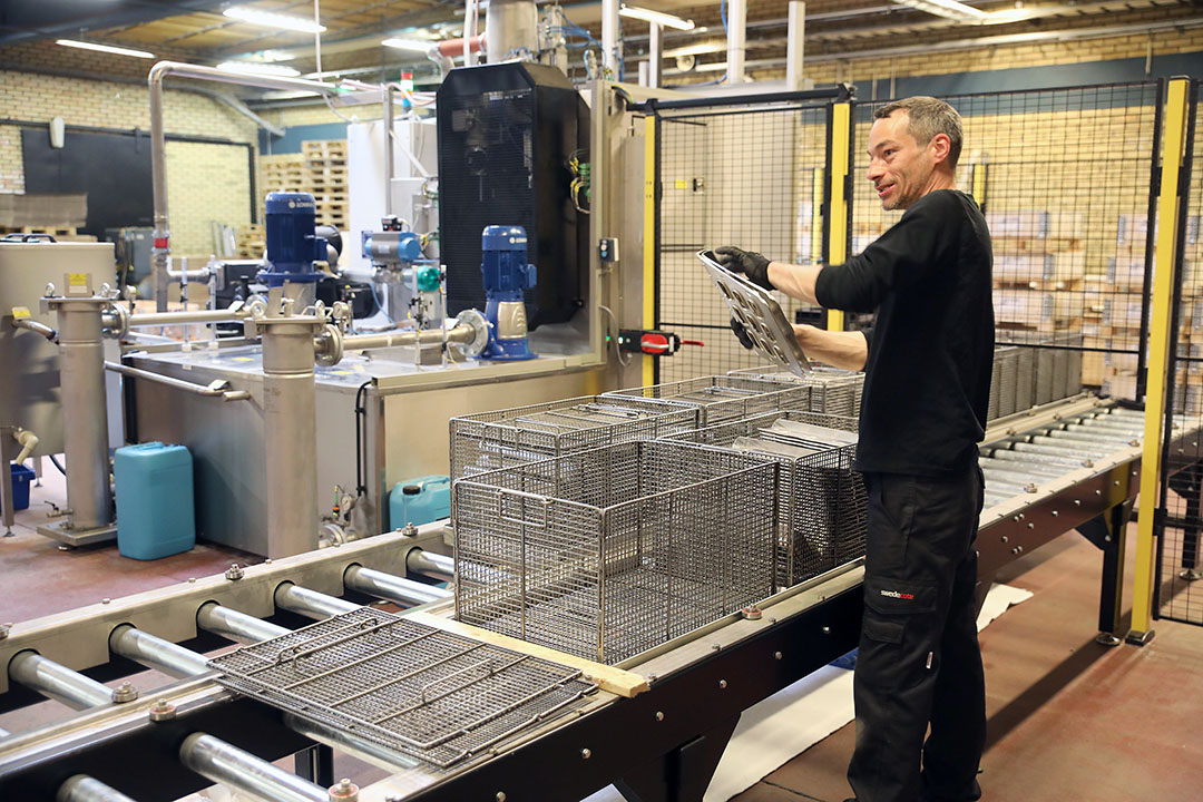 Swedecotes tvättanläggning är en en kombinerad flerstegsmaskin med separata enheter för tvätt och tork som matas med ett automatiserat beskickningssystem med rullbanor för in och utmatning av tvättgods.